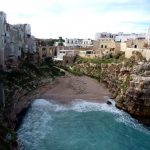 Baía com praia entre rochedo, Polignano a Mare, Itália