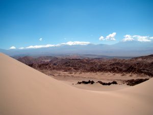 Dunas e picos nevados, no deserto do Atacama, Chile